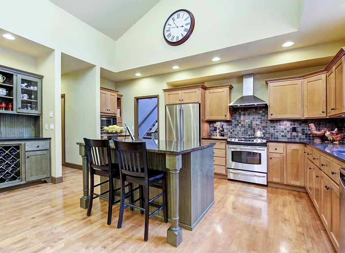 Granite Island, Slat-Front Bar Stools, and a Clock That Commands the Room
