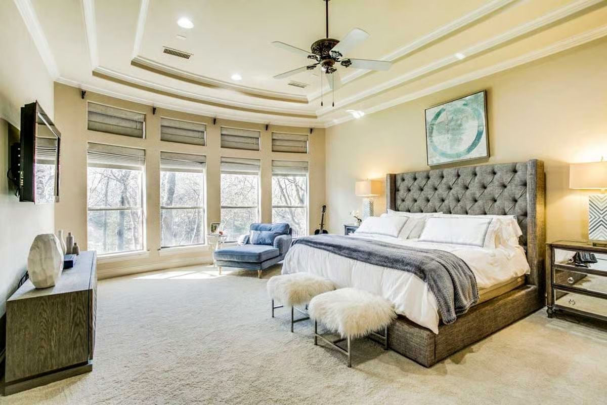 Tufted Headboard and Sheepskin Stools in a Room Built Around Natural Light
