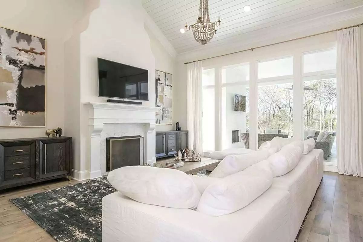 Cloudlike Sectional, Arched Fireplace Wall, and a Chandelier That Earns Its Keep