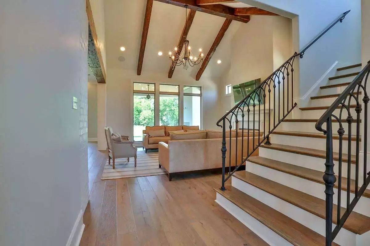 Wrought Iron Balusters and Exposed Ceiling Beams Do the Heavy Lifting Here