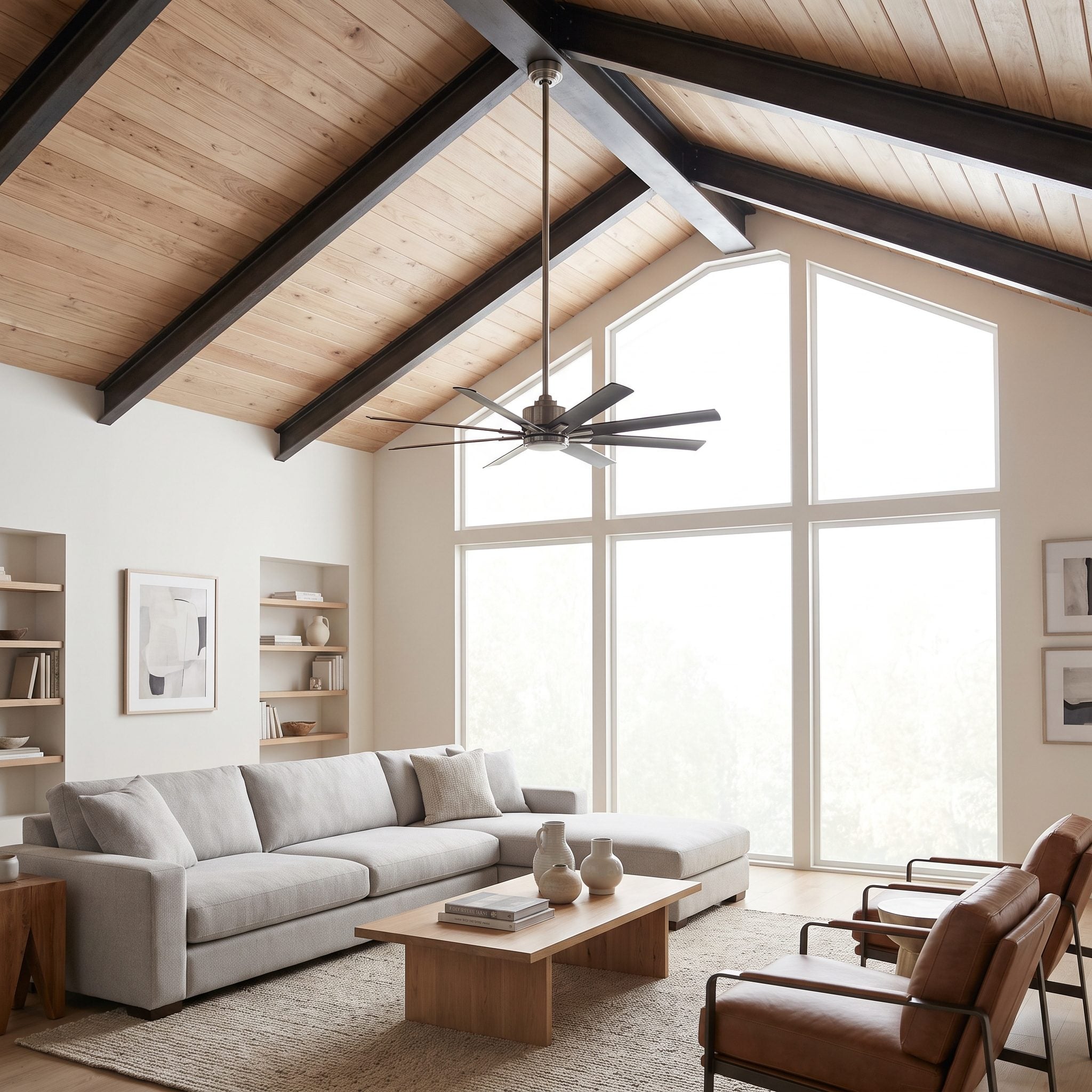 Great room with a black fan on a long downrod hung about nine feet above the floor under a vaulted ceiling that peaks near