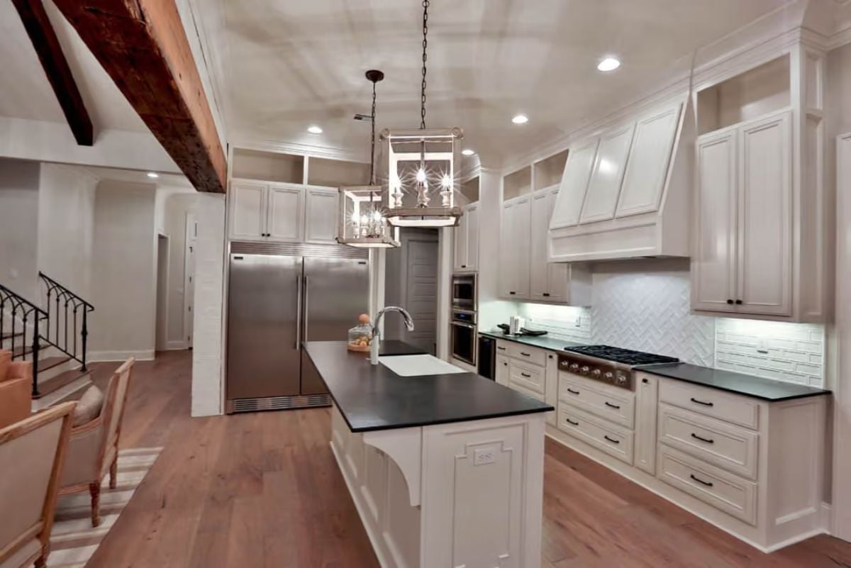 Black Countertops and Lantern Pendants Keep a White Kitchen From Going Soft
