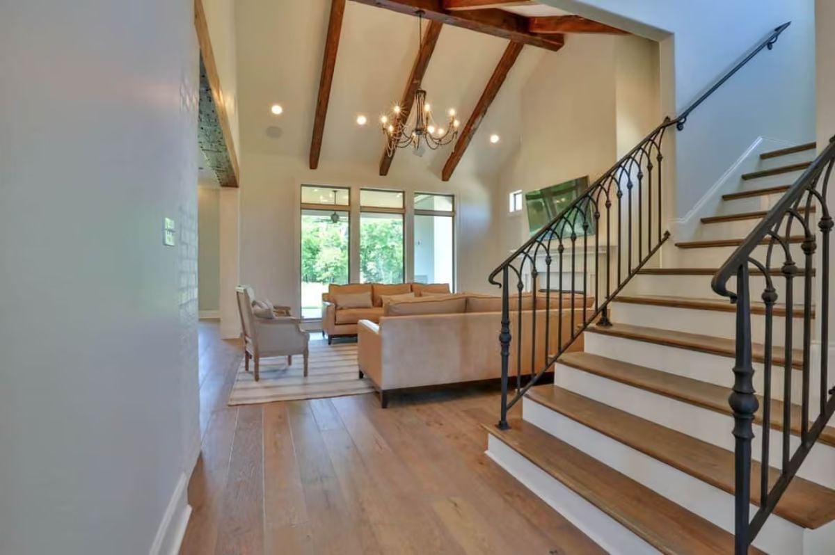 Exposed Beams and Iron Balusters Set the Tone Before You Reach the Living Room