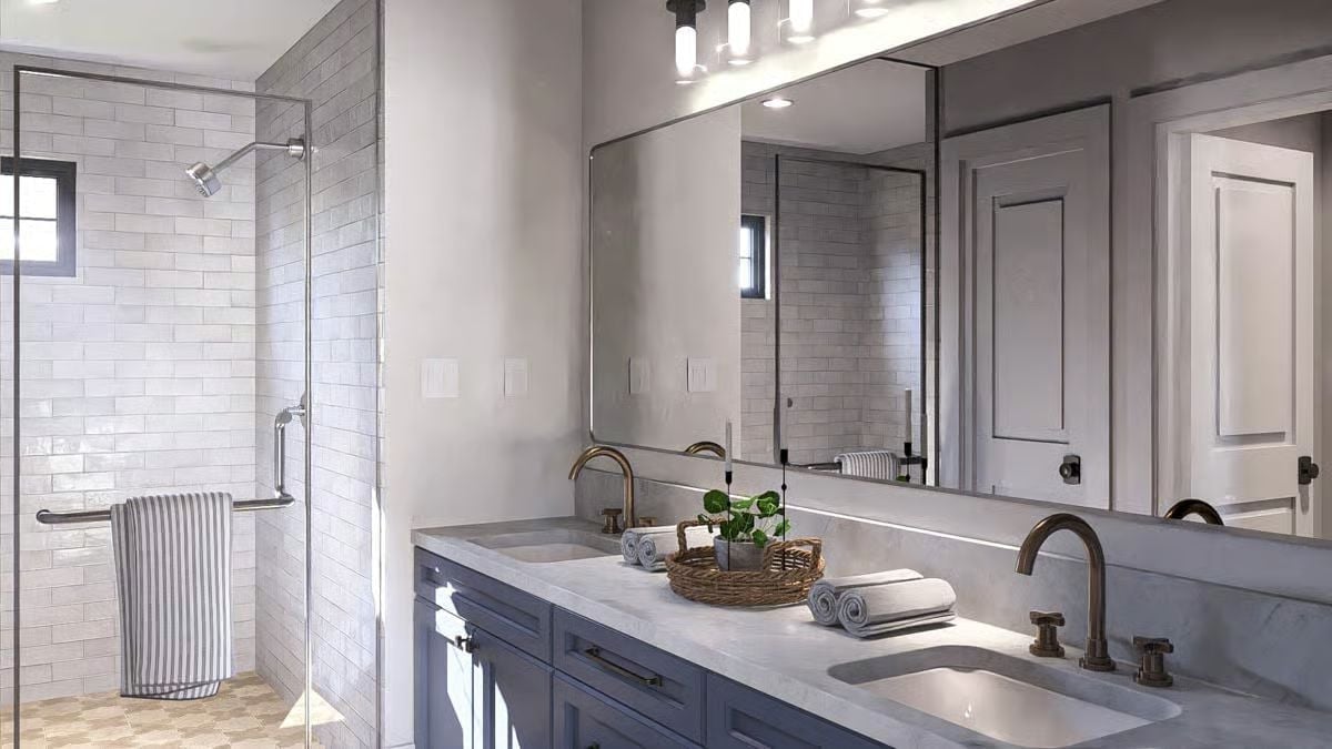 Brass Faucets and Blue Cabinetry in a Bathroom That Pulls Its Weight for Two