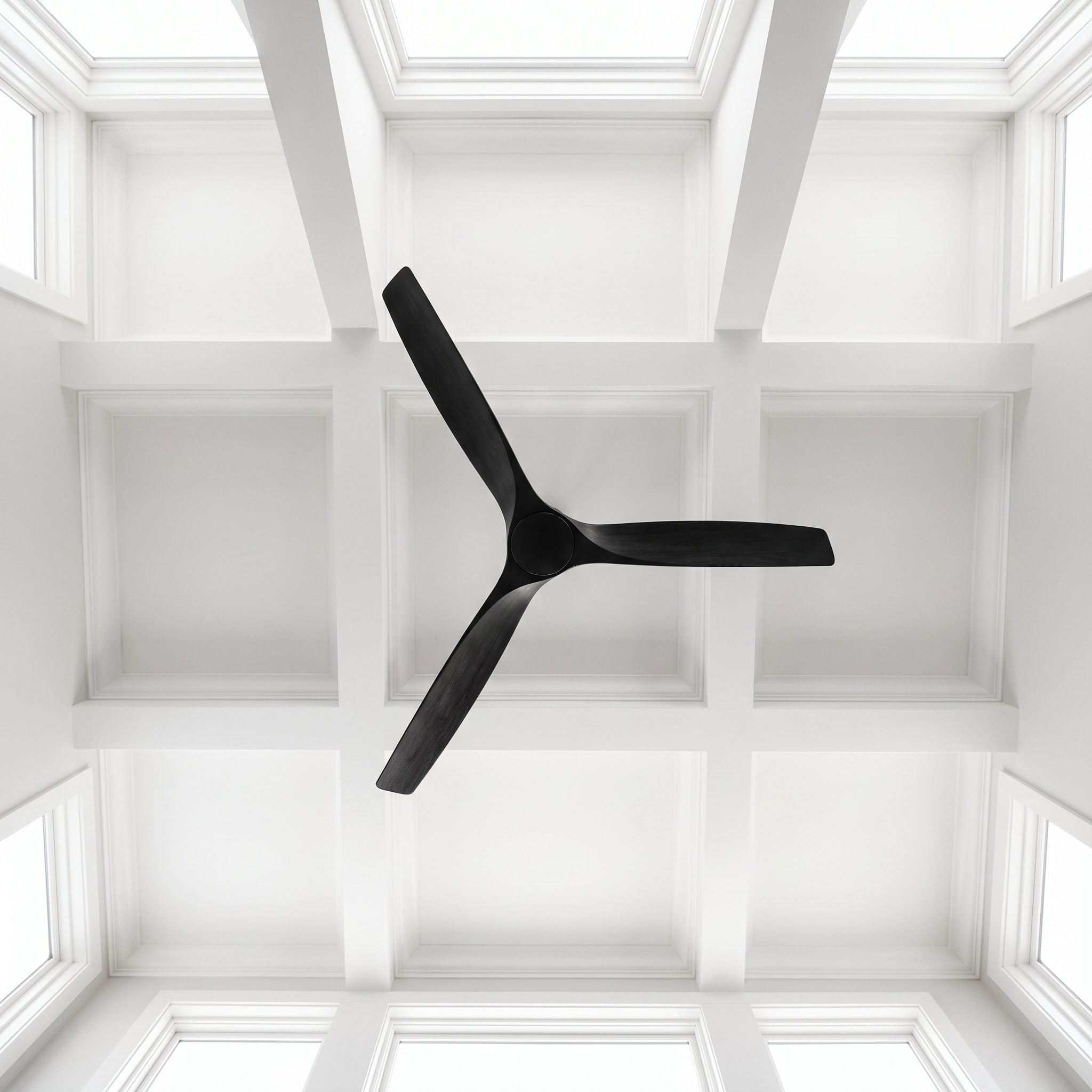 Living room with a matte-black three-blade ceiling fan mounted close to a white ceiling above an 84-inch sofa, with black