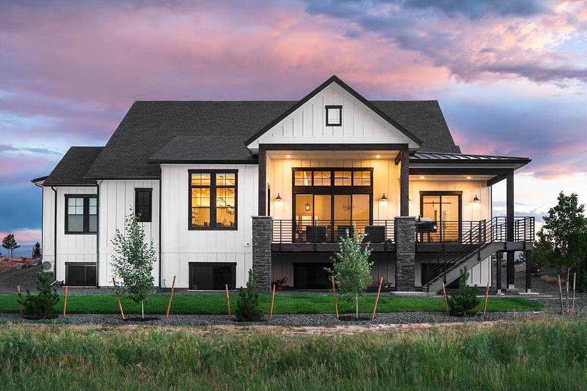 Warm Light Spills Across a Modern Farmhouse Rear at Dusk