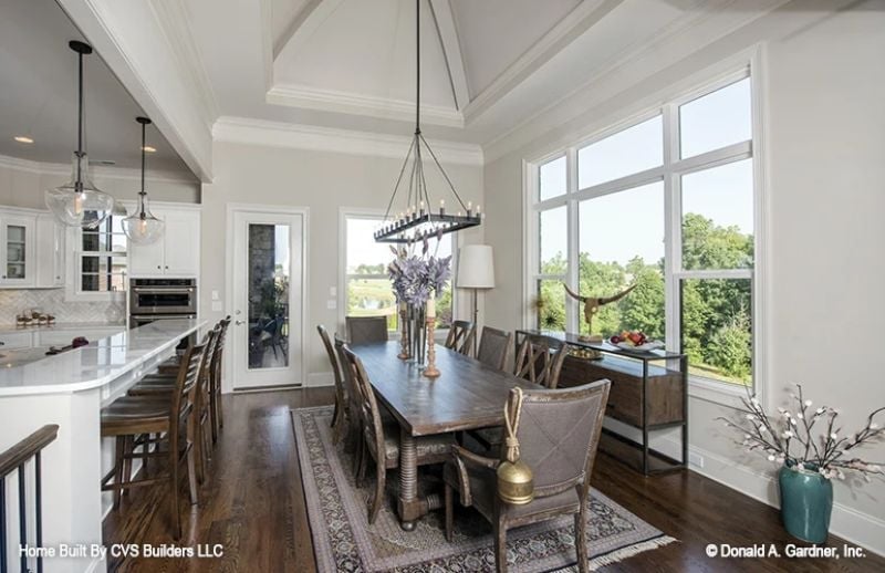Rectangular Iron Chandelier, Dark Wood Table, and a View That's Doing Most of the Work