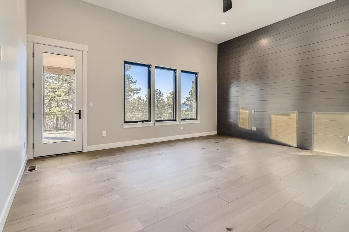 Dark Shiplap Accent Wall, Light Floors, and a Door That Opens to the Trees