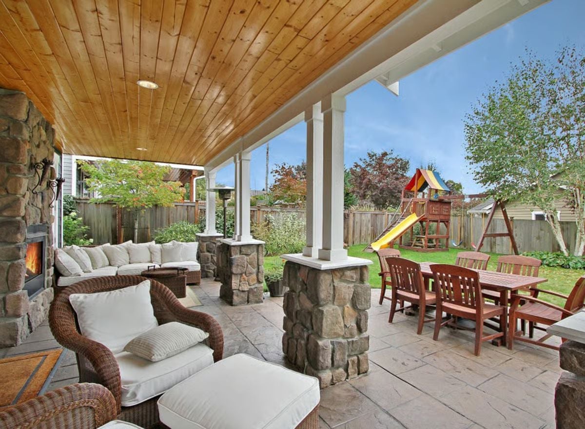 Stone Columns and a Wood Ceiling Make This Covered Porch Feel Like a Real Room
