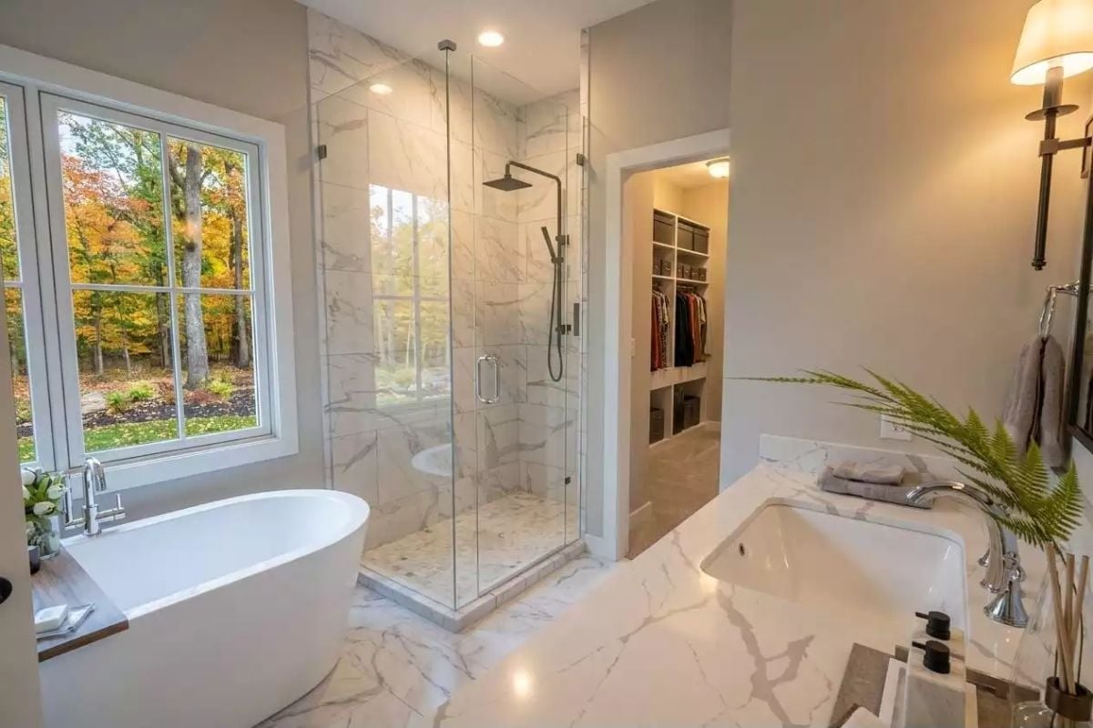 Marble Shower Surround With a Walk-In Closet Visible Through the Door