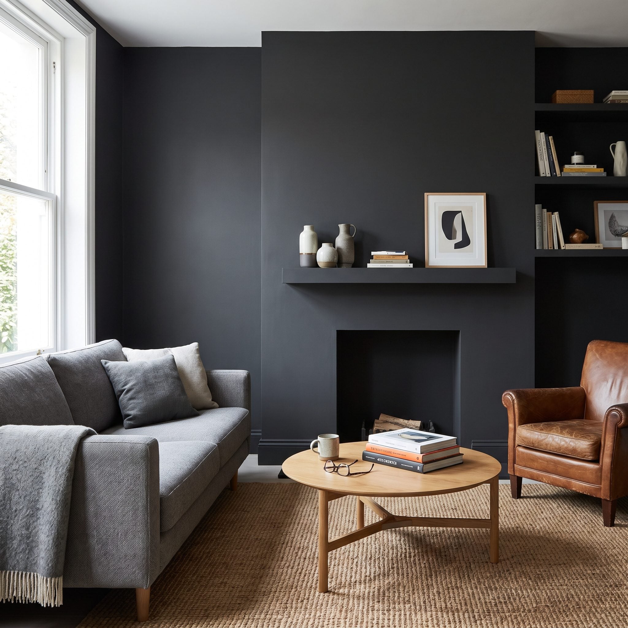 Charcoal living room with the fireplace, mantel, and surrounding wall painted the same dark color