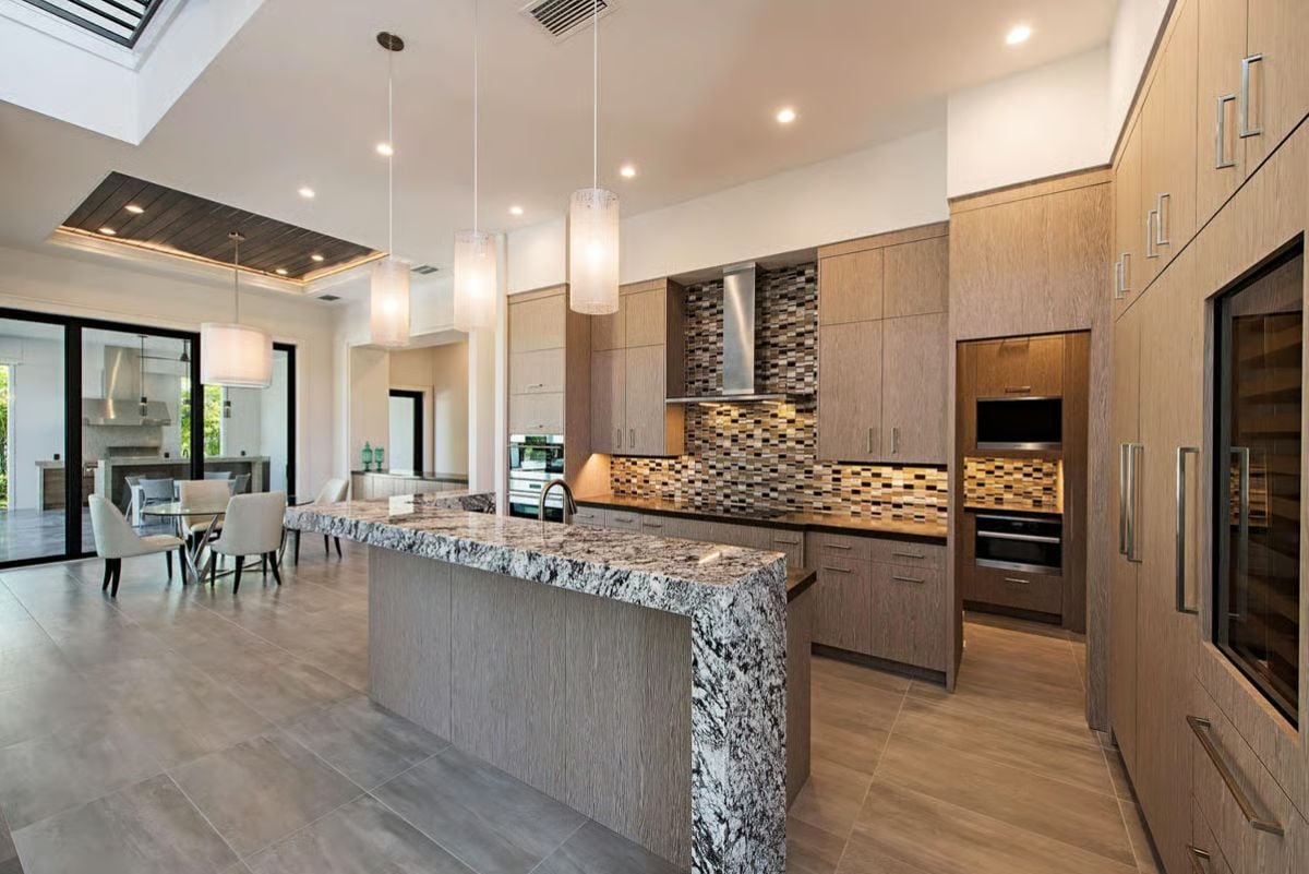 Waterfall Granite and Layered Lighting Make This Kitchen Hard to Leave