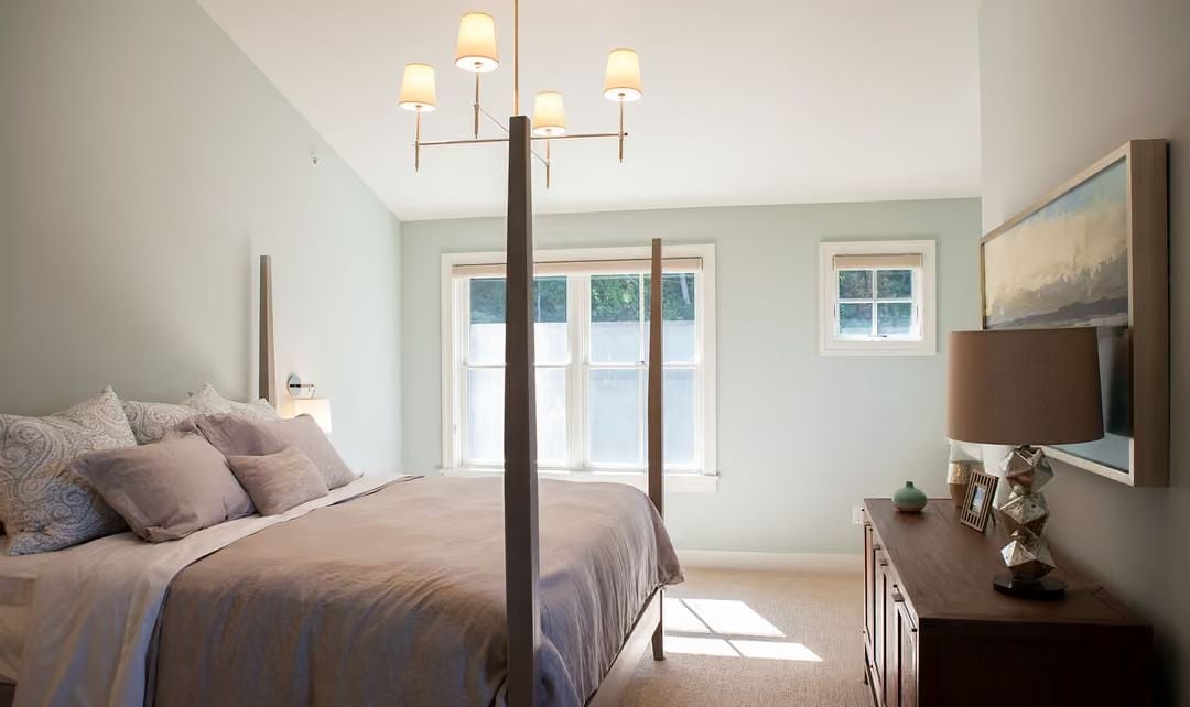 Four-Poster Frame, Soft Sage Walls, and Light That Does the Heavy Lifting