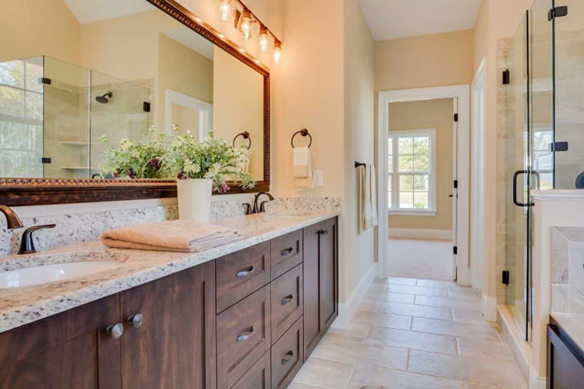 Dark Vanity Cabinets, Granite Counters, and Glass That Earns Its Square Footage
