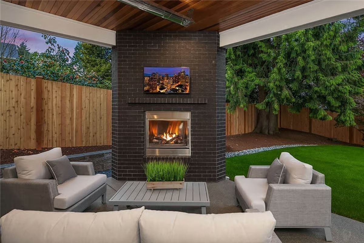 Covered Patio Built Around a Fireplace That Works Hard Enough to Justify Every Seat