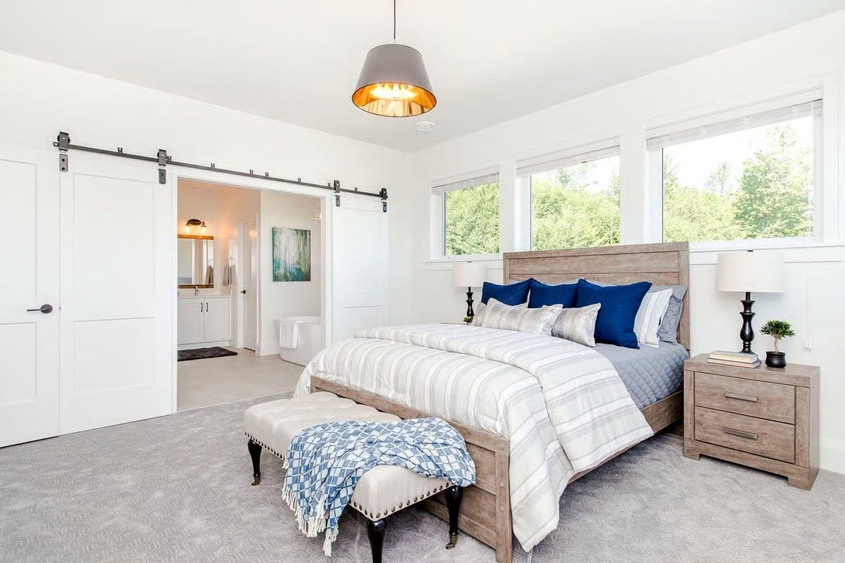 Barn Door Hardware and Navy Pillows Doing the Heavy Lifting in This Master Suite