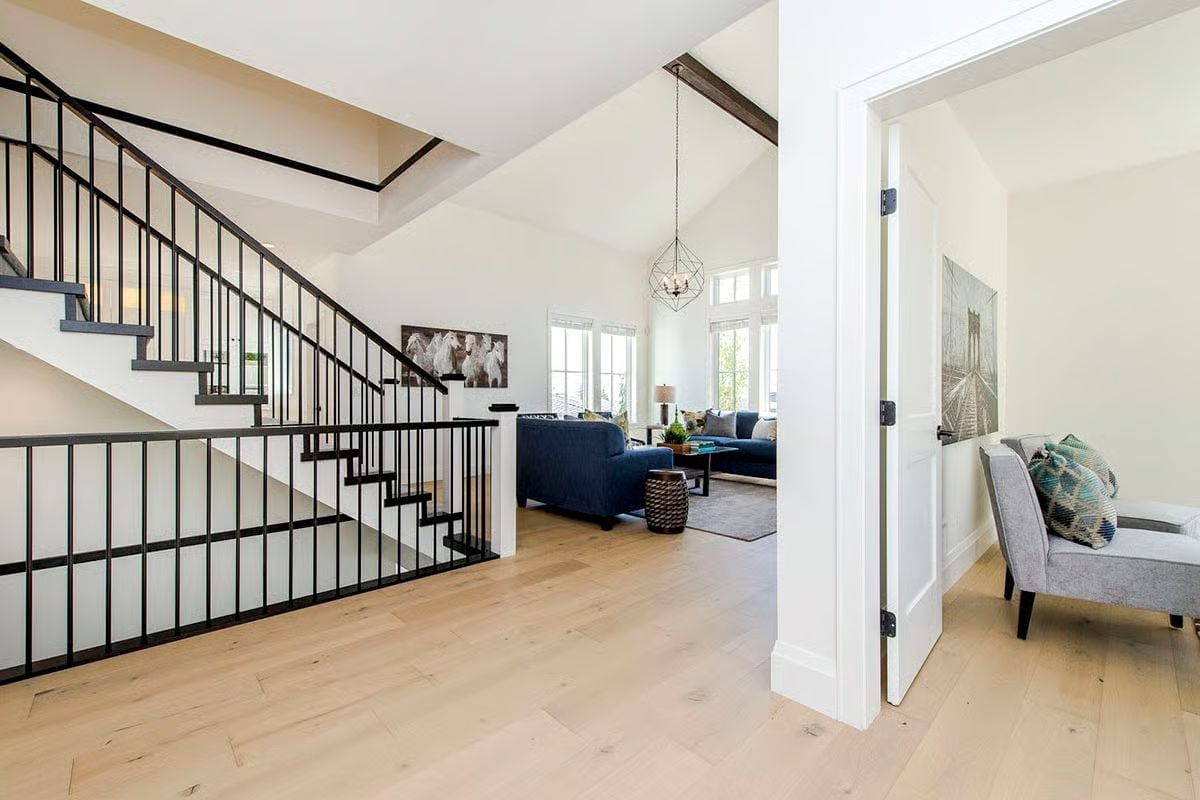 Black Iron Railings and Pale Oak Floors Set the Tone Before You Say Hello