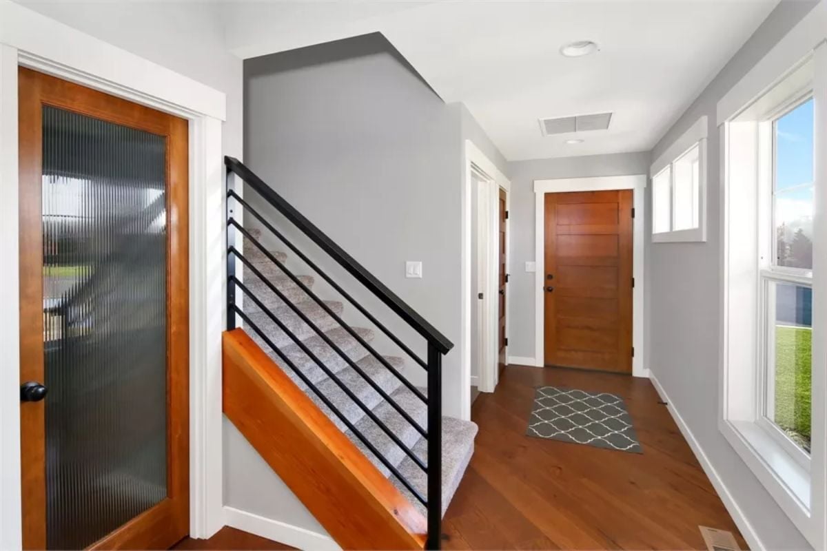 Warm Wood Doors and Black Steel Railings Make a Strong First Impression