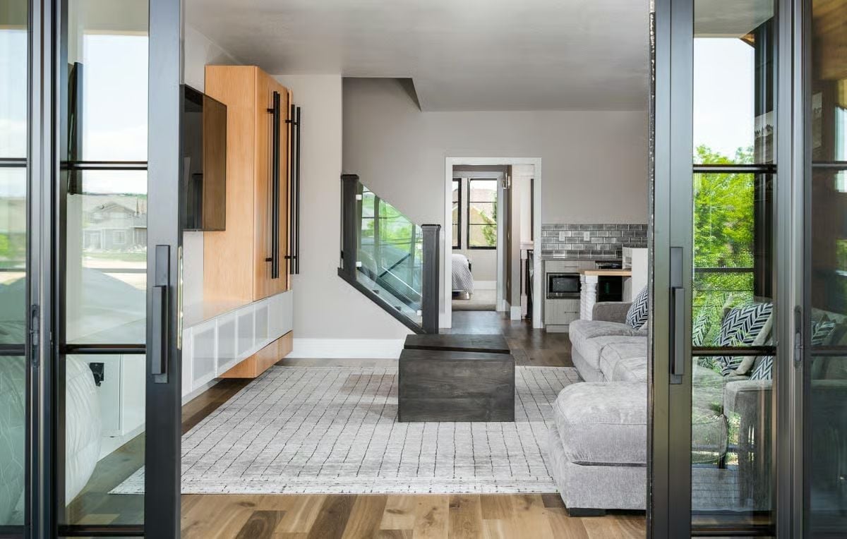 Glass-Panel Stair Rail and a Wood Entertainment Wall Walk Into the Same Room