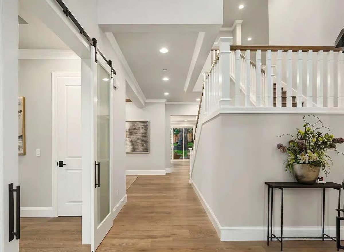 Frosted Barn Door, White Balustrade, and a Hallway That Actually Breathes