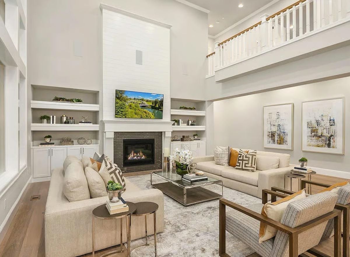 Painted Brick Fireplace, Two-Story Ceiling, and Sofas That Invite You to Stay