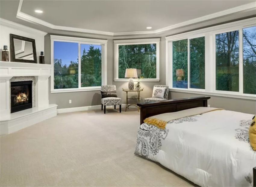 Carpeted Master Suite Where the Fireplace and Bay Windows Split the Room's Attention