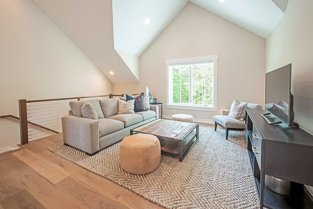 Vaulted Bonus Room with Hardwood Floors That Pulls Double Duty as a Loft Retreat