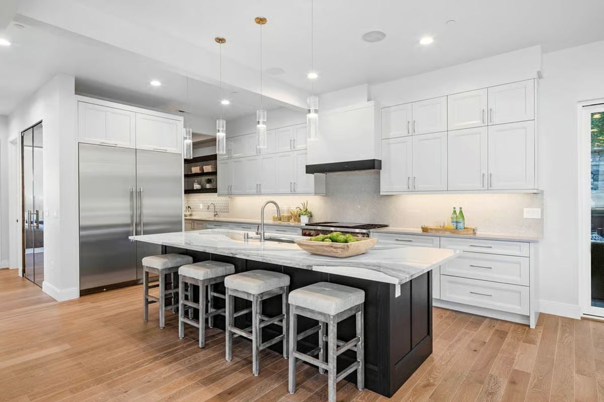 Dark Island Base Against White Cabinetry Is a Studied Contrast That Earns Its Keep