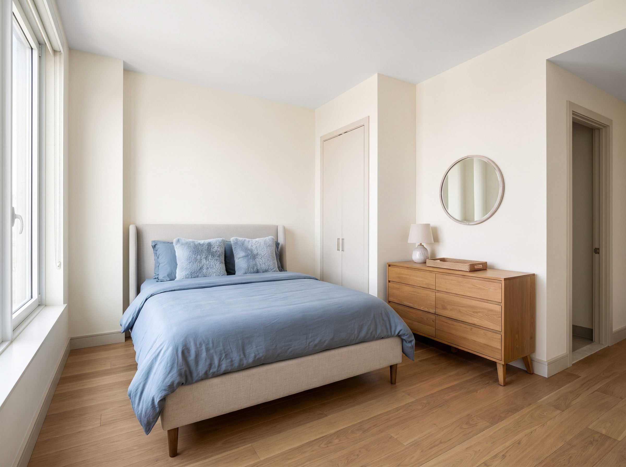 Small bedroom with a shallow oak dresser flat against the right wall and about three feet of clear floor in front of the