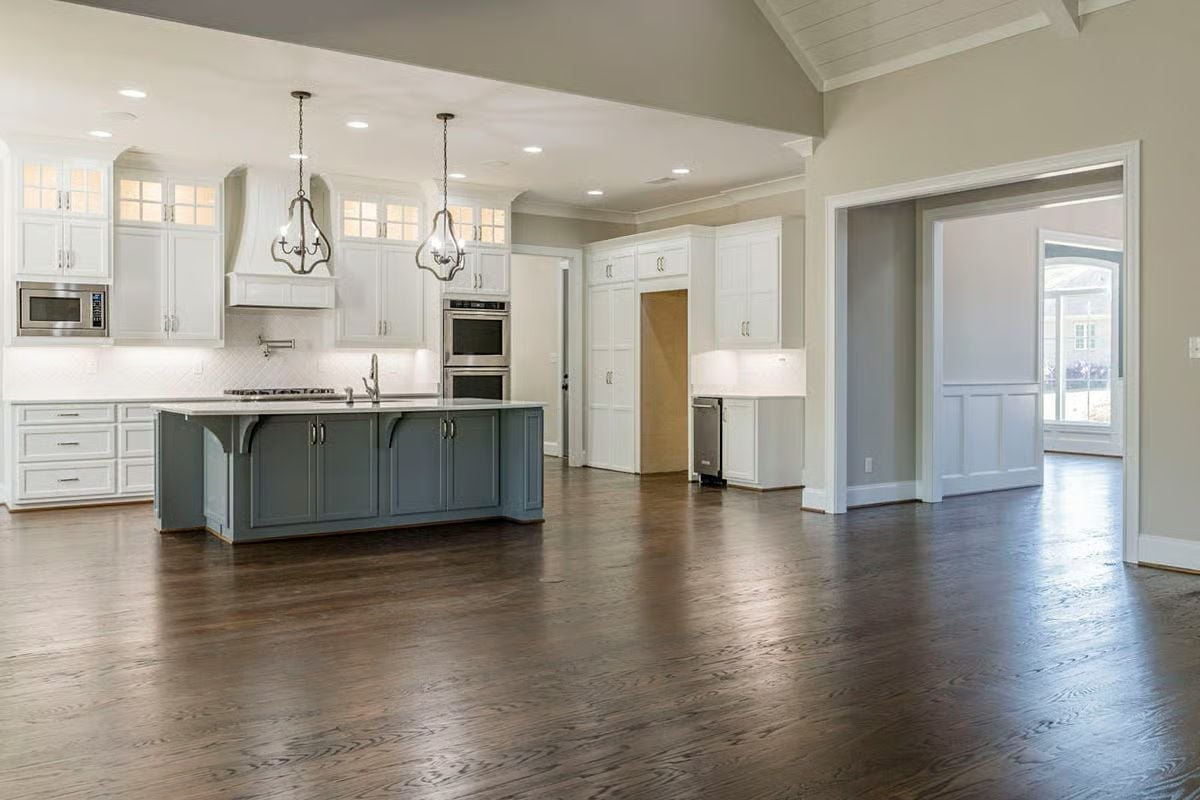 Dark Hardwood Floors Anchor a Kitchen Built Around Its Island