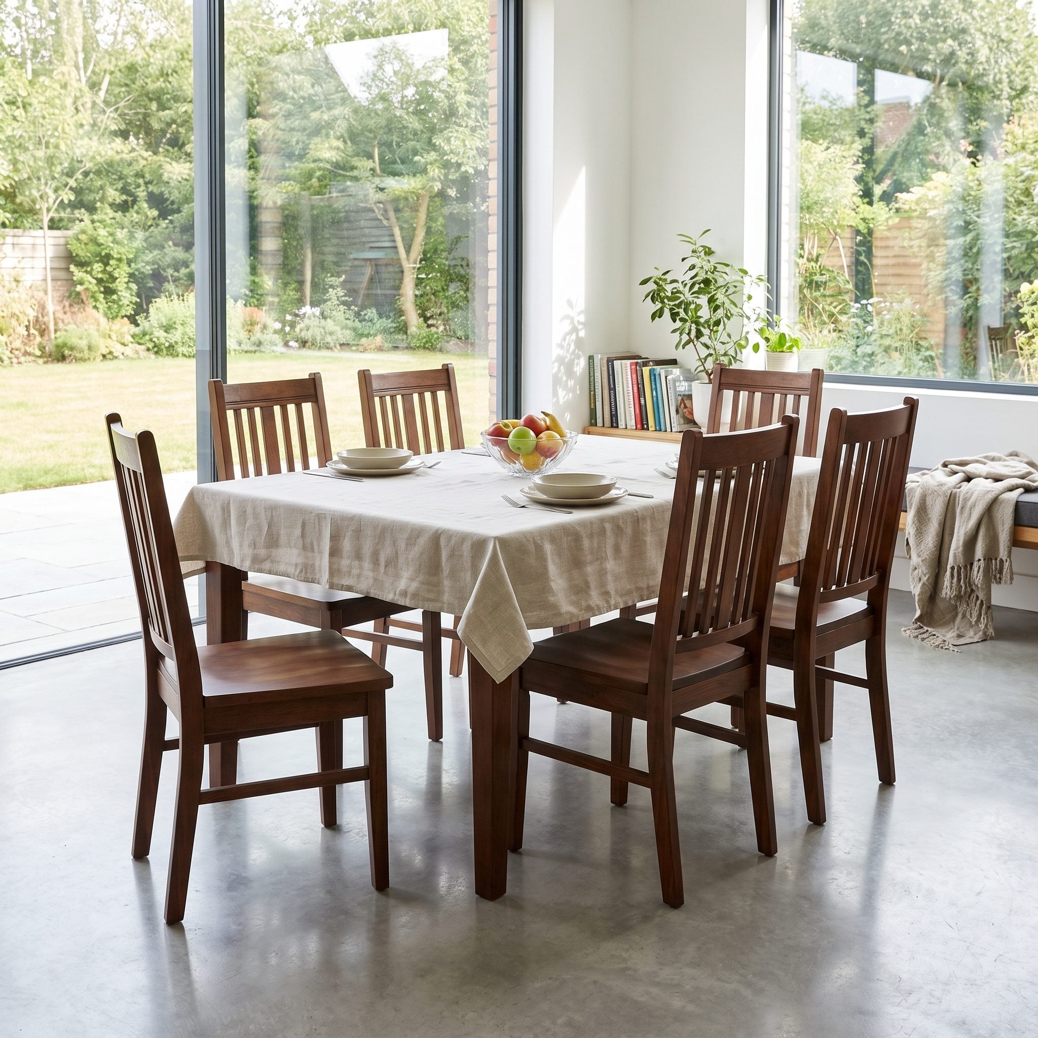 Contemporary dining room with a matching mahogany table, six carved chairs, and a matching sideboard against a white plaster