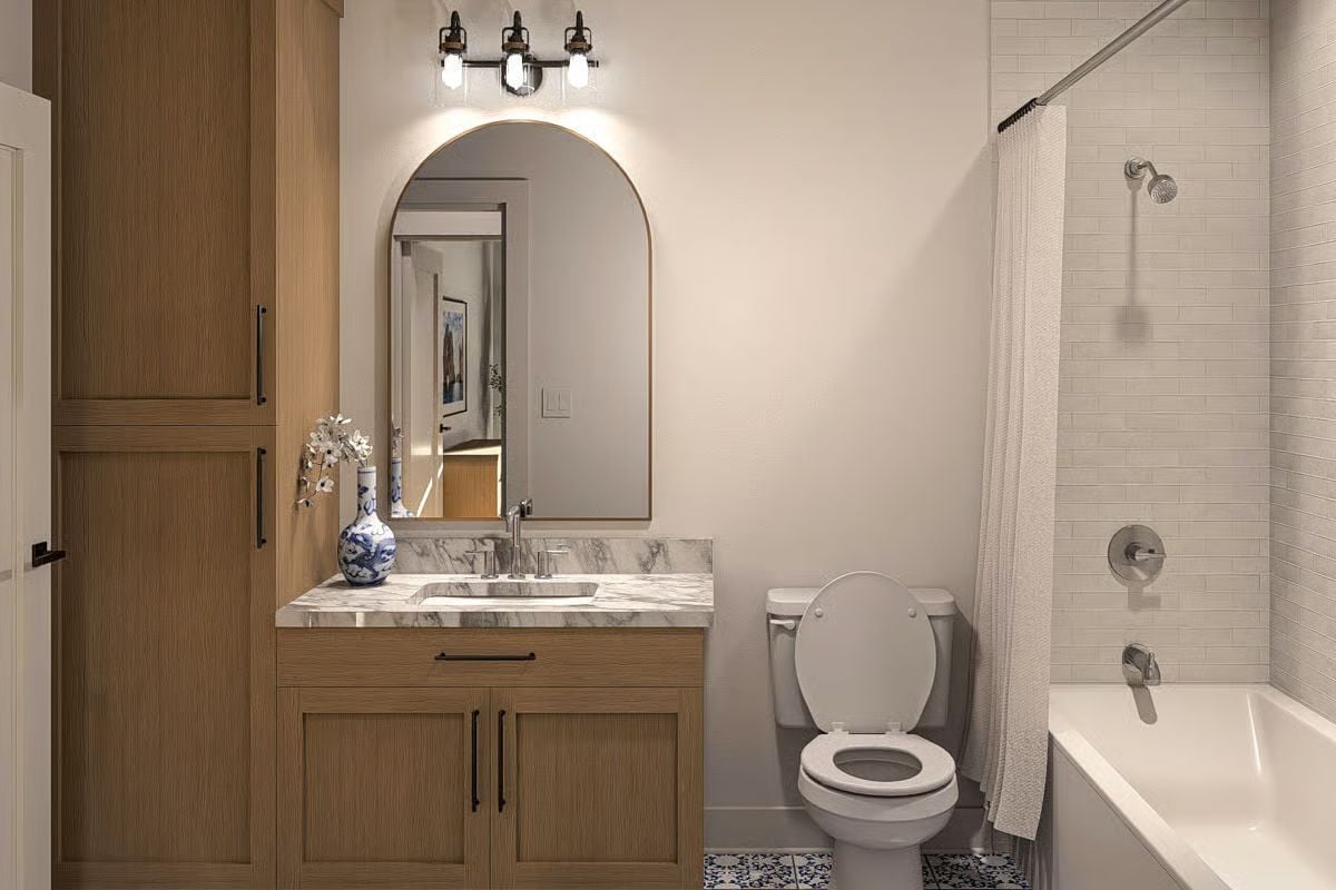 Arched Mirror and Marble Counter Make a Small Bathroom Feel Intentional