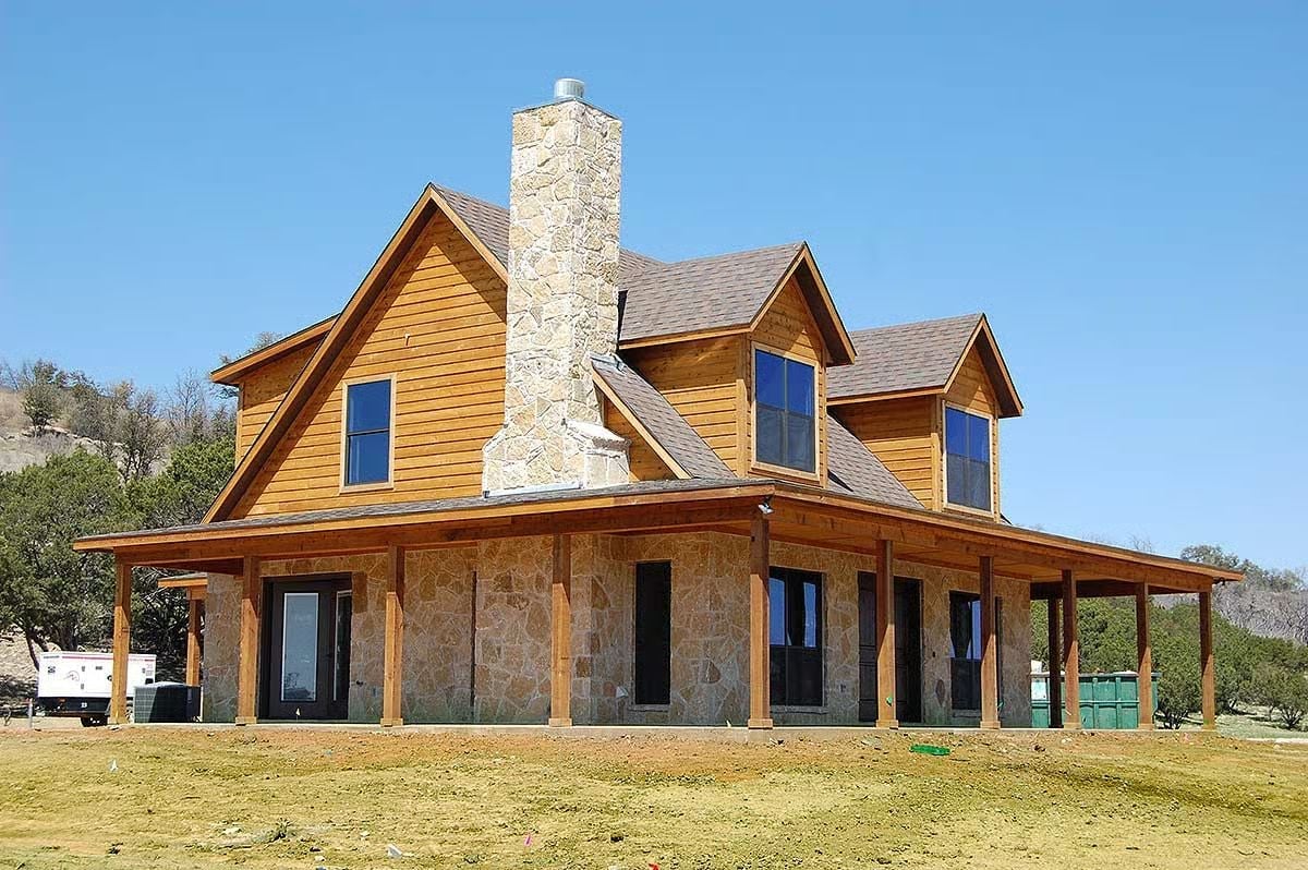 Limestone Chimney, Cedar Siding, and a Porch That Wraps the Whole Front