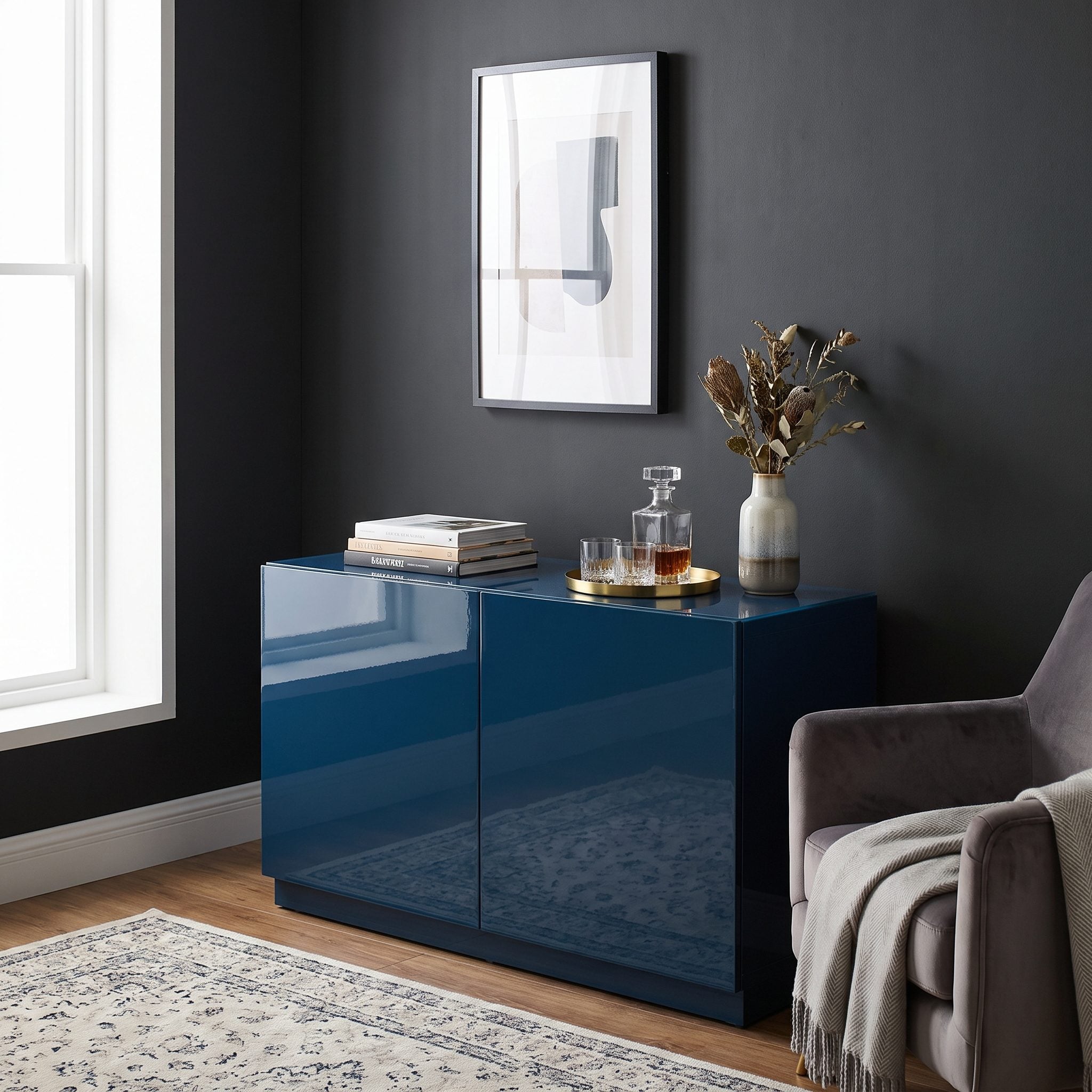 Dark navy living room with a mirror, brass lamp, and lacquered table catching the light