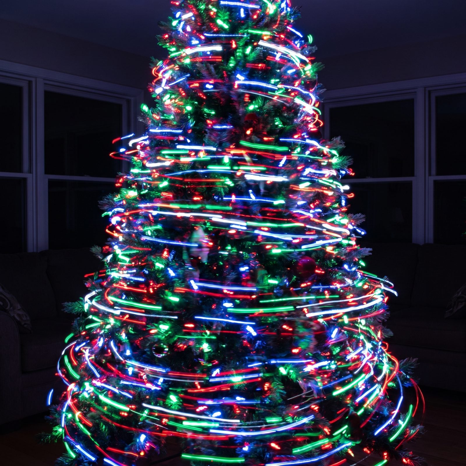 Artificial tree set to a flashing chase pattern breaking the light into bright spots and dark gaps.