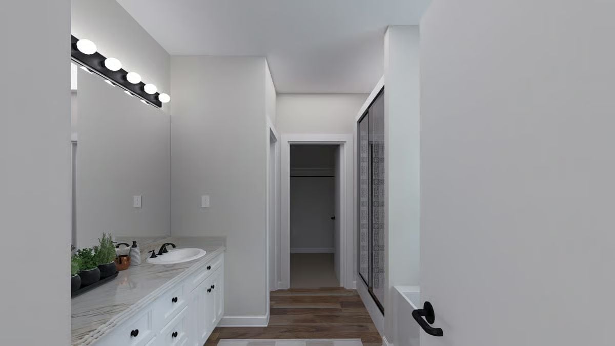 Hollywood Vanity Lighting and a Walk-In Closet Doorway Make This Bathroom Work Harder