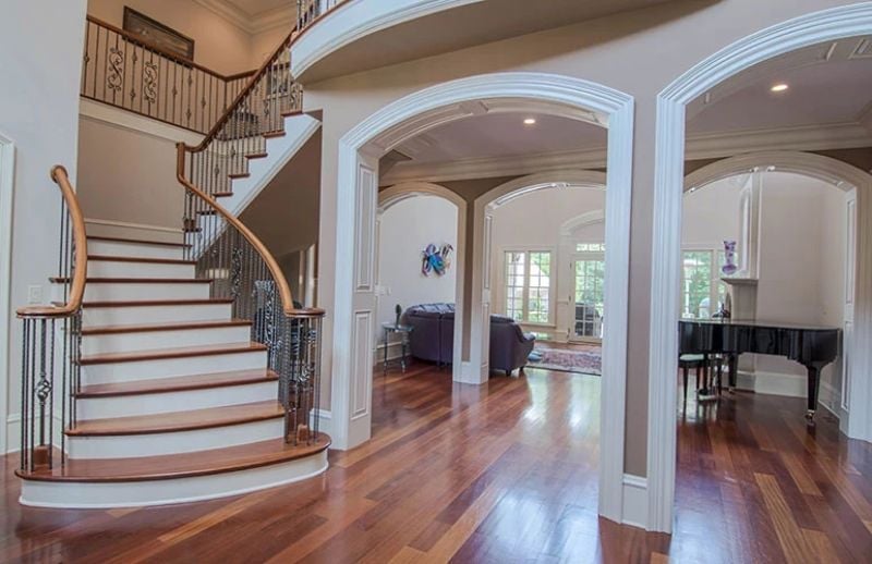 Curved Staircase and Double Arches Set the Tone Before You Reach the First Room