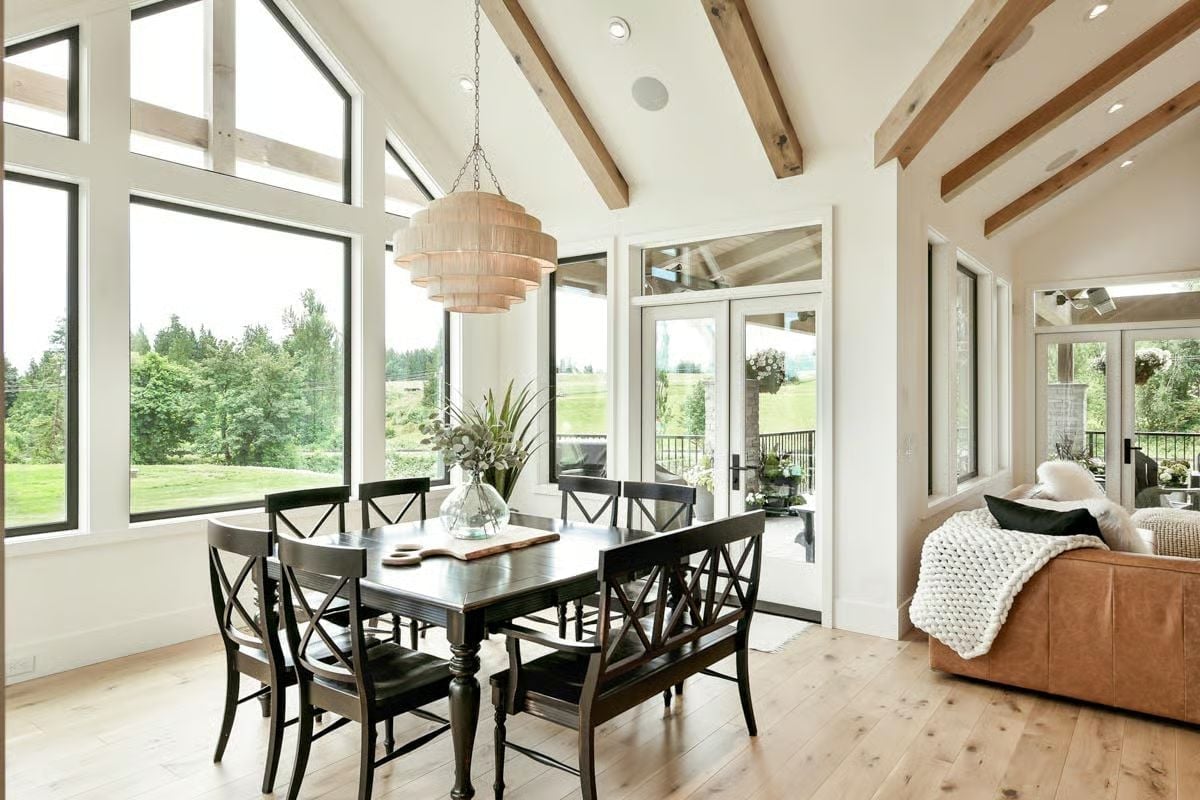 Vaulted Dining Room Where Black Furniture Holds Its Own Against a Wall of Glass