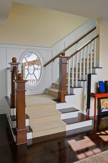 Oval Window on the Landing Gives This Staircase Something to Look At