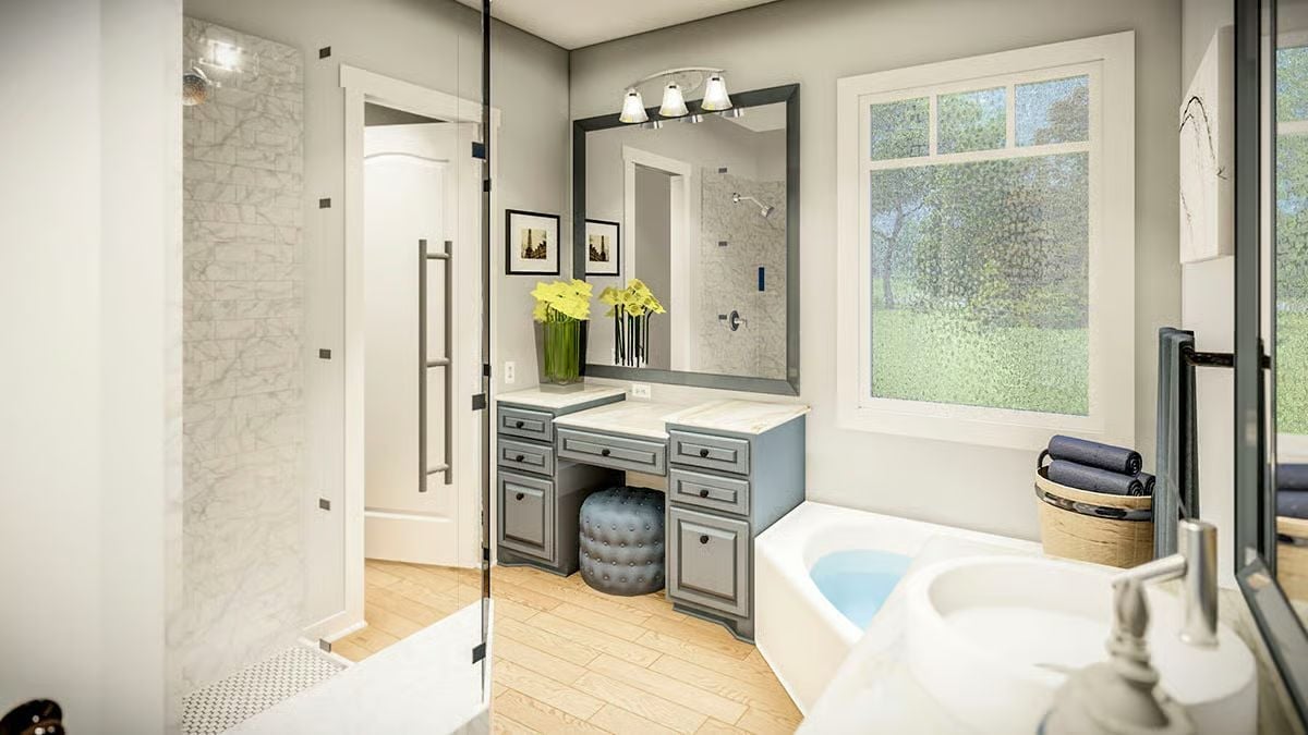 Gray Vanity, Glass Shower, and a Soaking Tub Positioned to Catch Natural Light