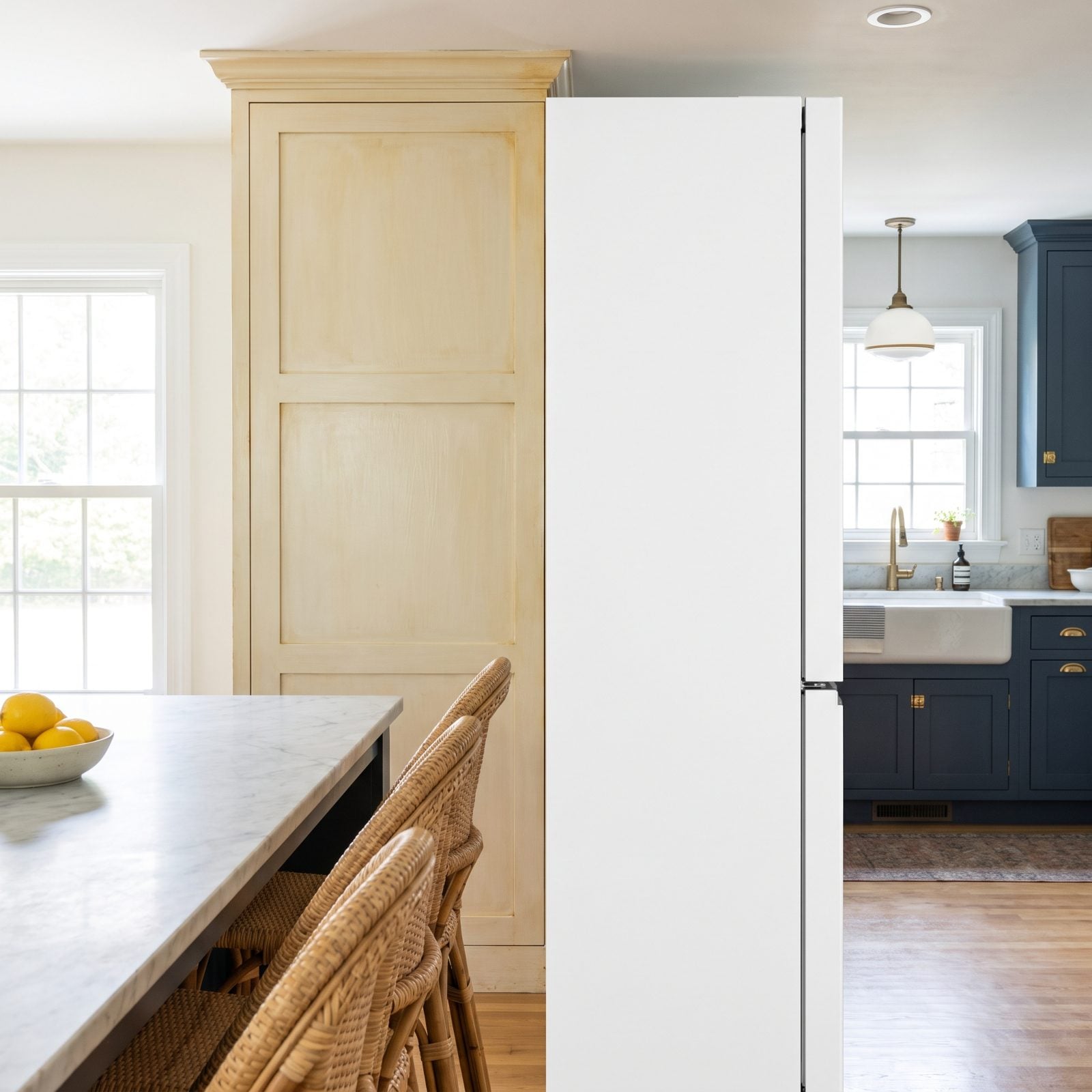 Yellowed White Cabinets Beside a Bright White Refrigerator