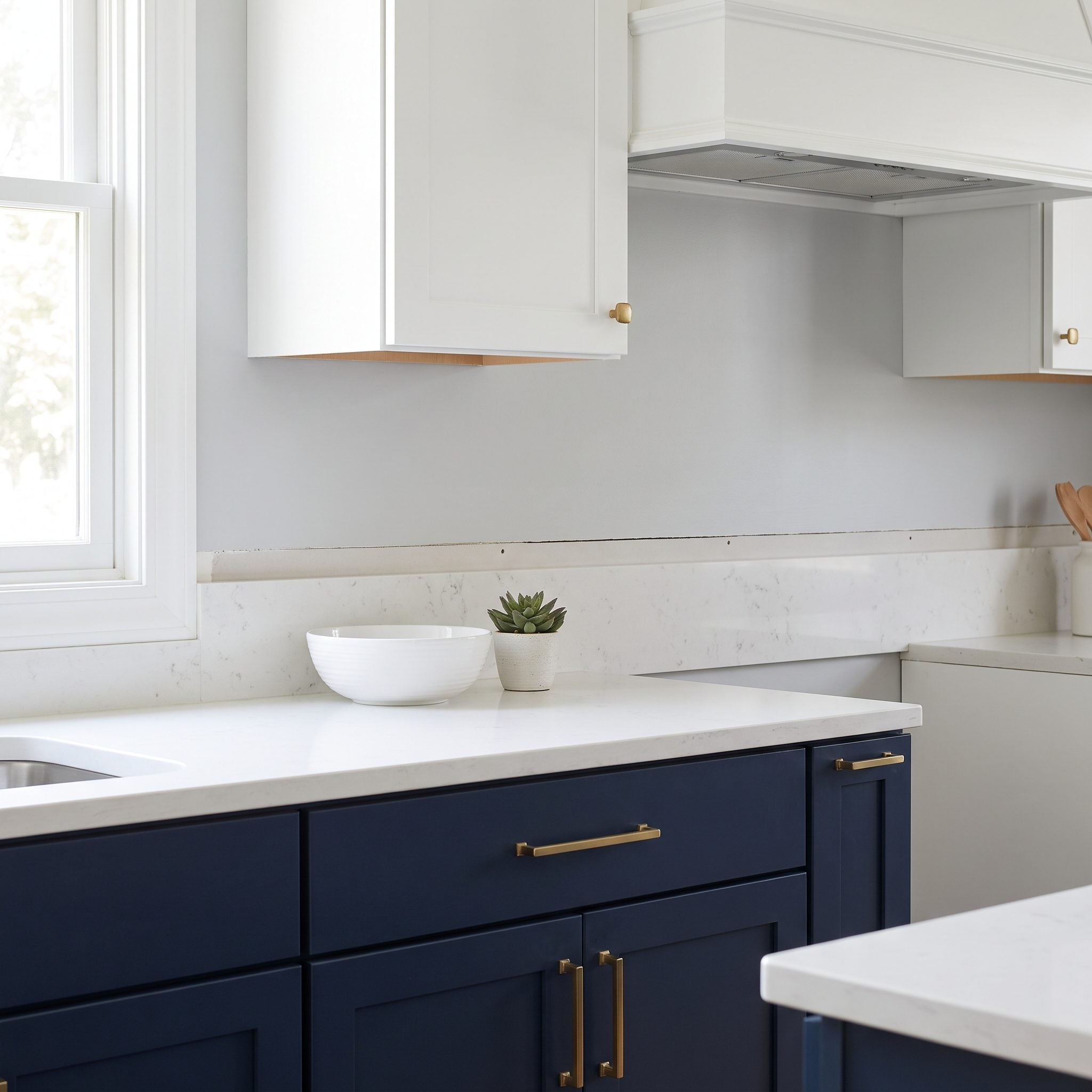 Navy kitchen transformation with vertically stacked white ceramic backsplash tile extending to the upper cabinets