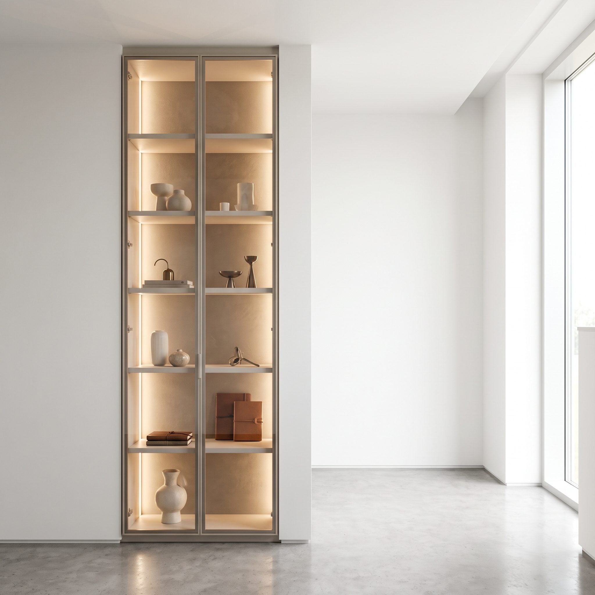 Narrow bedroom alcove fitted with illuminated glass-fronted display cabinets and drawers for accessories