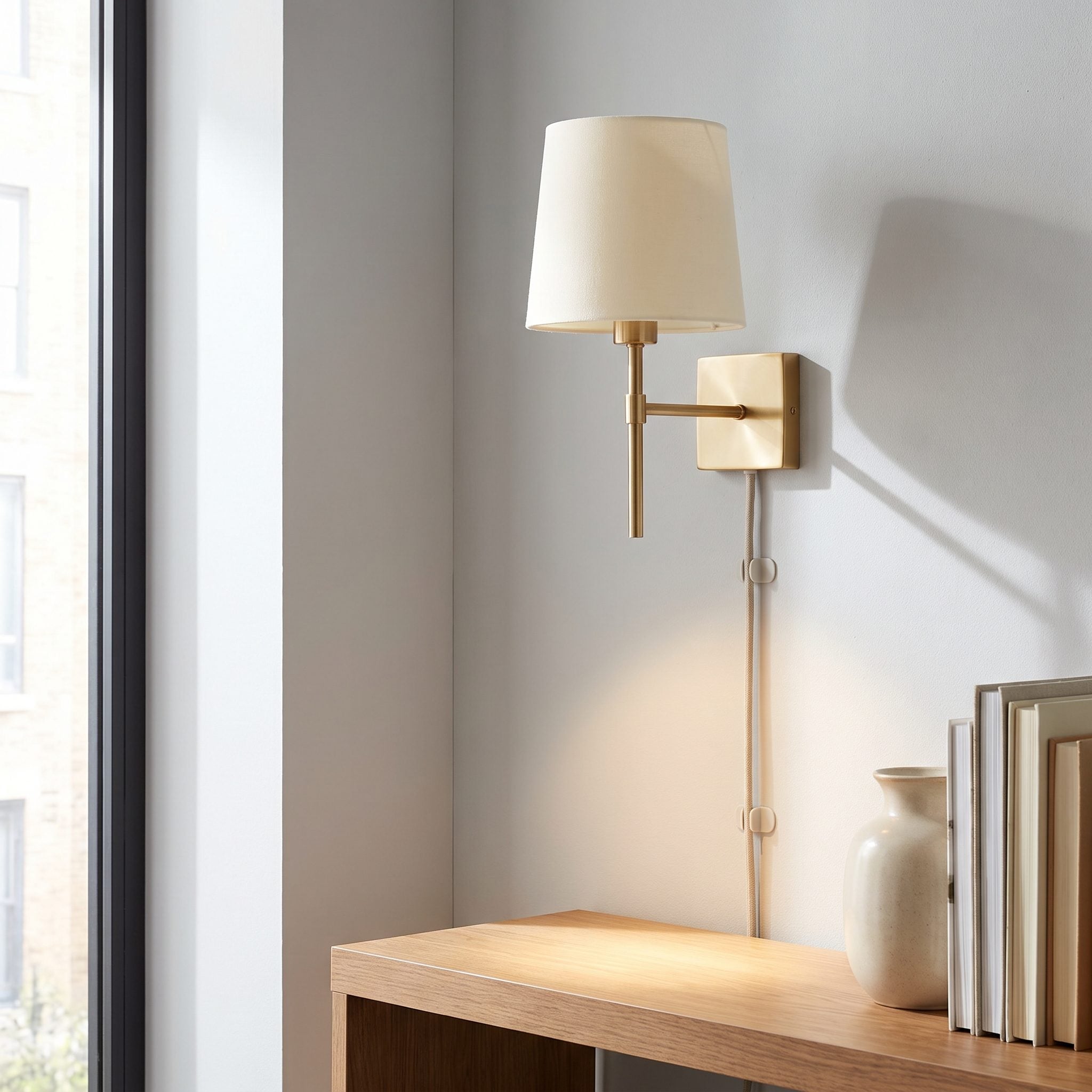 Built-in shelves flanked by brass plug-in wall sconces