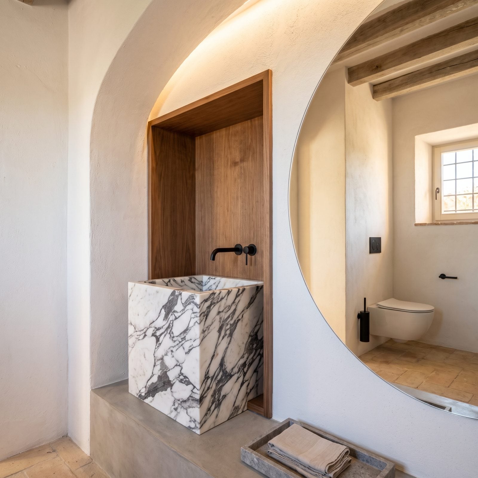 An Arabescato Cube Sink Set Into a Walnut Niche