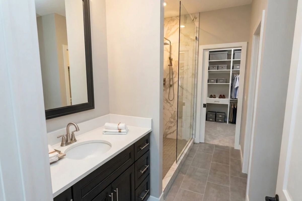 Glass Shower, Marble Tile, and a Walk-In Closet Visible from the Vanity