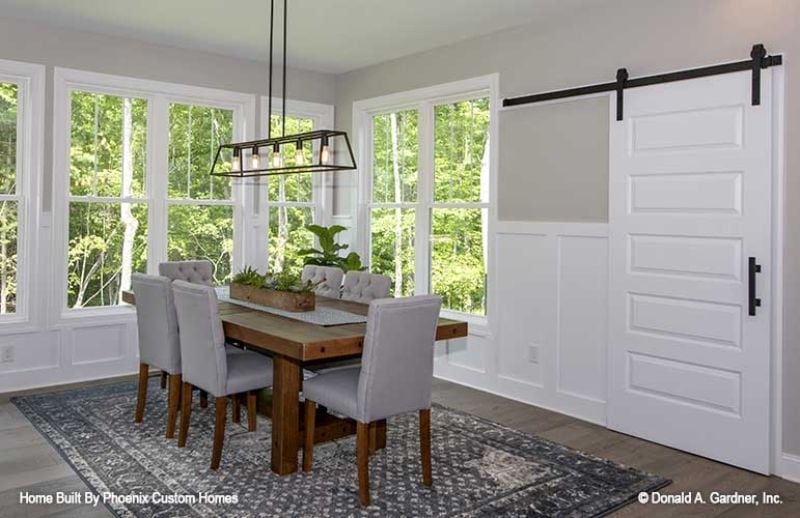 Sliding Barn Door, Tufted Chairs, and Windows That Pull the Forest Inside