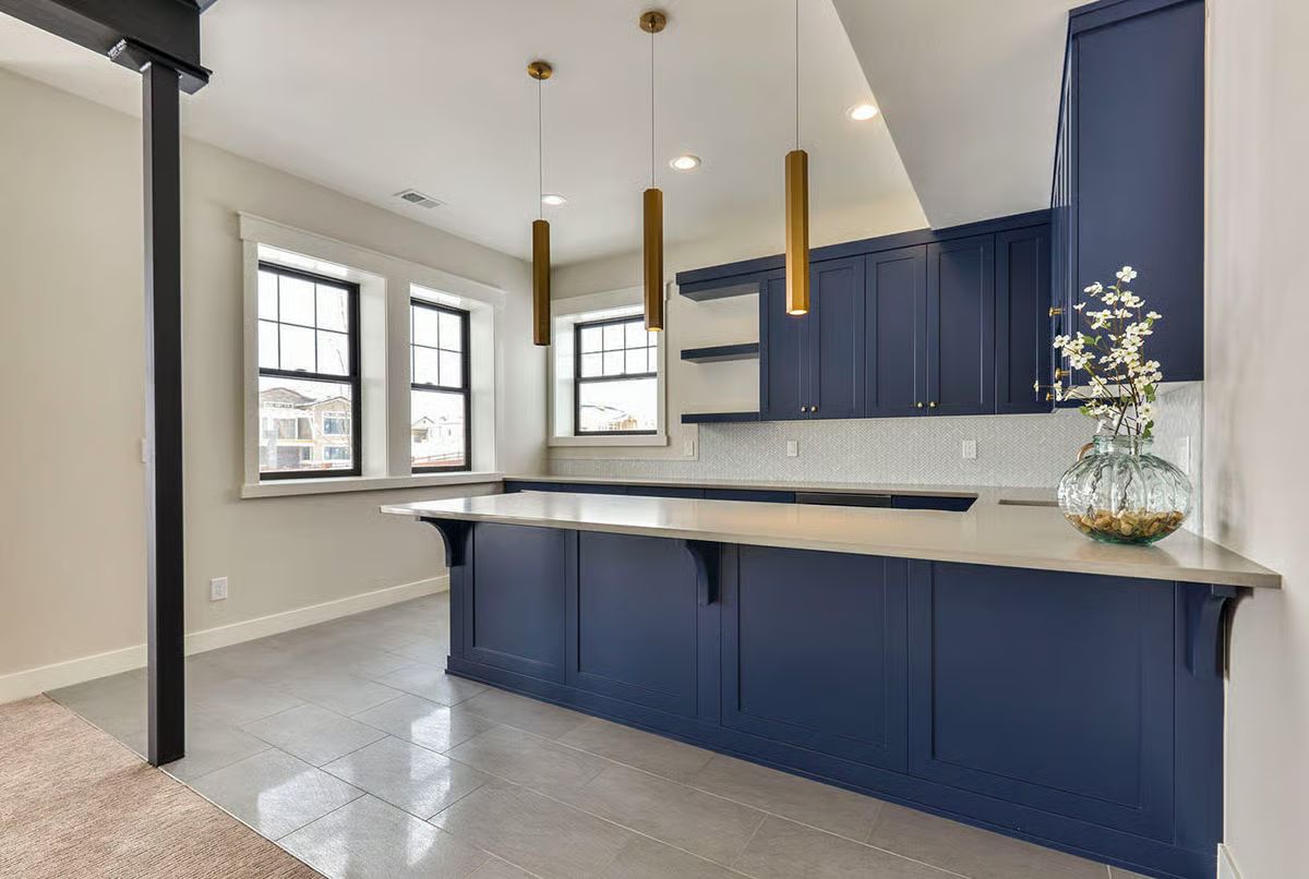Navy Cabinets and Brass Pendants Doing the Work in a Kitchen Built to Last