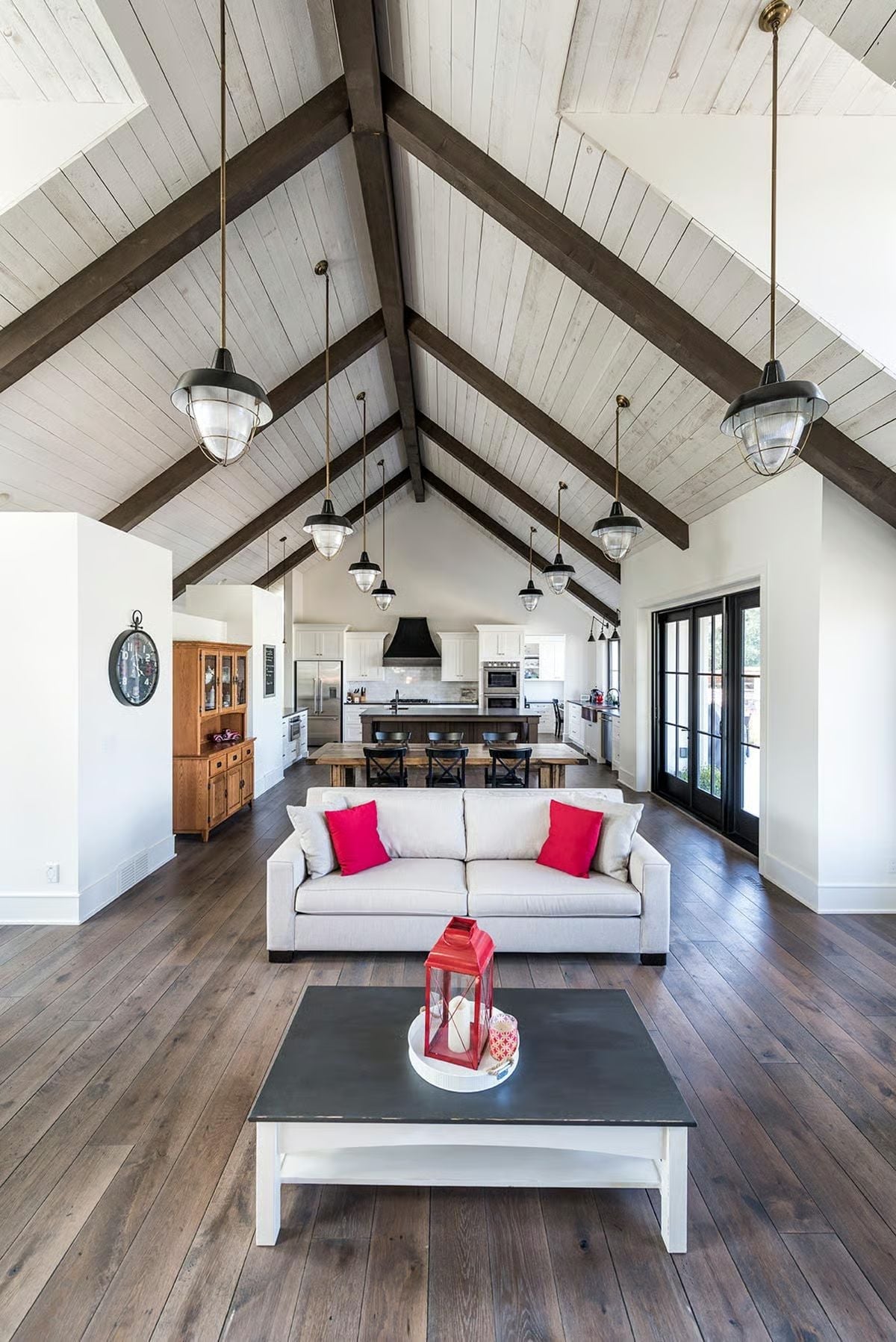 Cathedral Ceiling With Dark Timber Beams and Pendant Lights Hung on Long Brass Cords