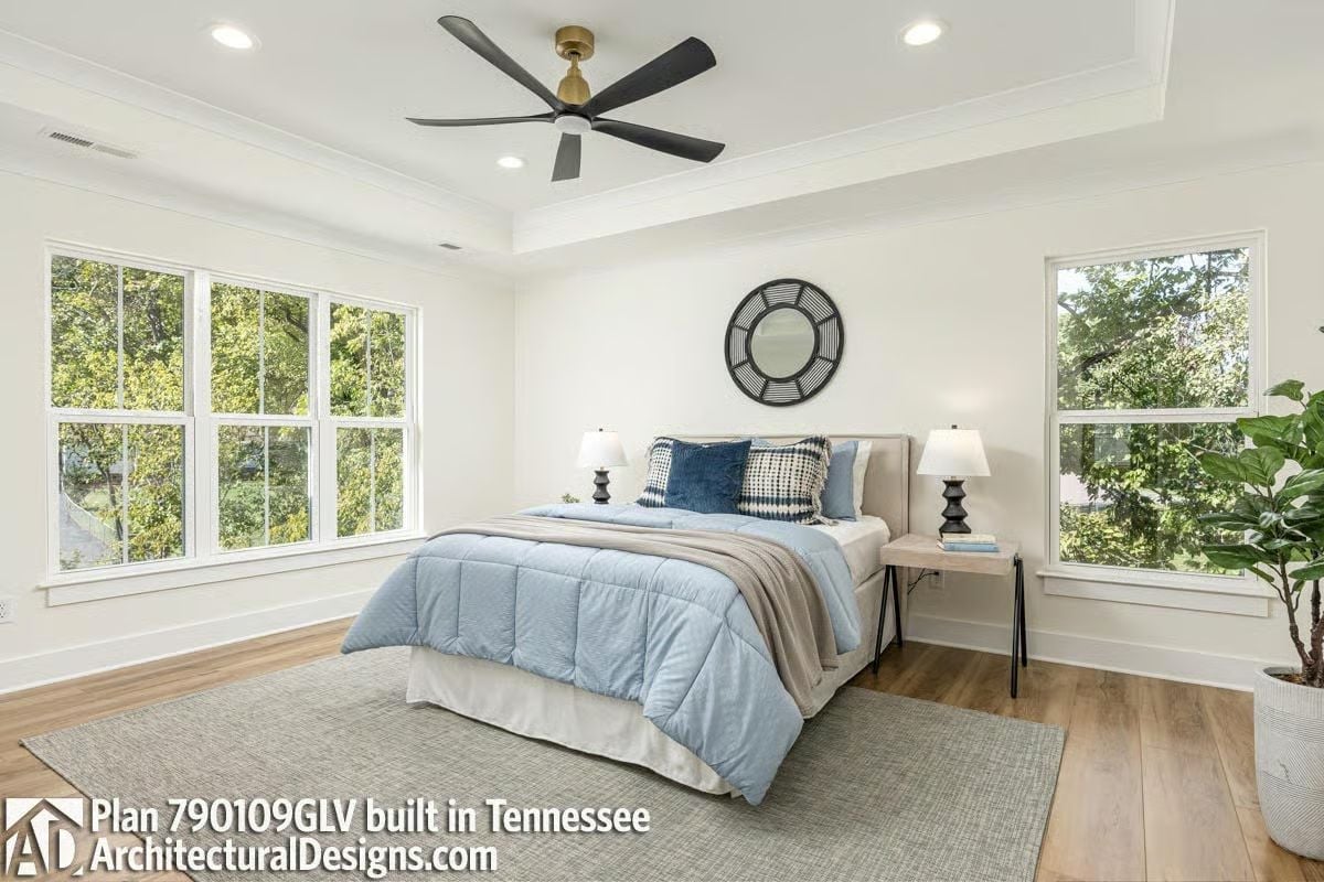 Tray Ceiling, Ceiling Fan with Brass, and Blue Bedding That Keeps Things Grounded